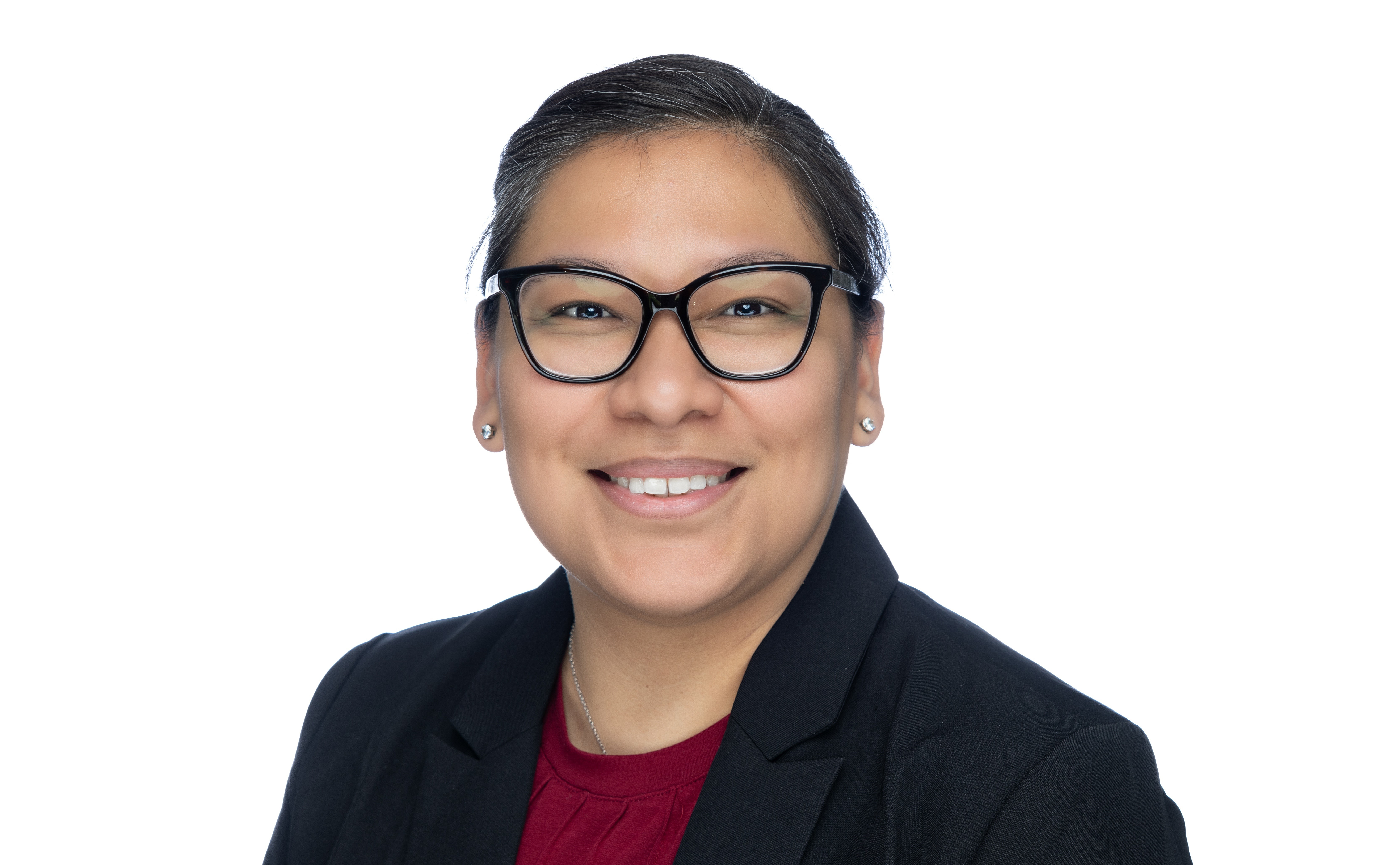 Picture of woman in glasses smiling for headshot. She is wearing a red shirt and a black coat. 